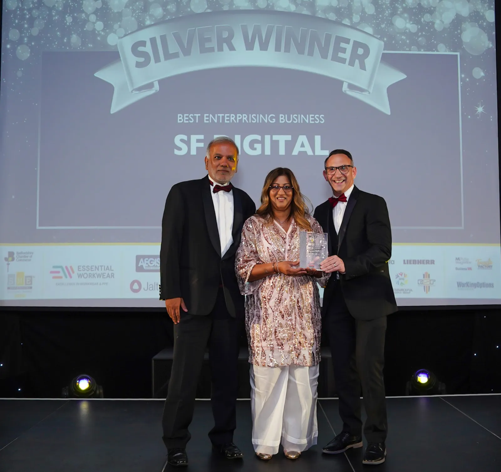 Uzair and Farzana on stage collecting the Silver award for Best Enterprising Business at the SME Bedfordshire Business Awards 2025