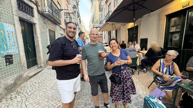 Three people from the group smiling outside the restaurant