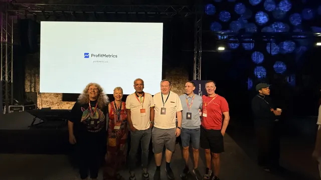 A group photo in front of the stage screen