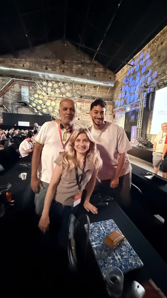 Uzair with two attendees between the desks in the main hall